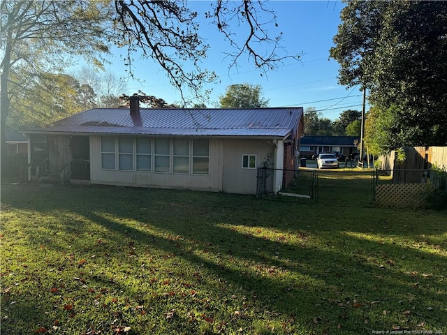 rear view of house featuring a lawn