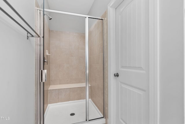 bathroom featuring a shower with shower door