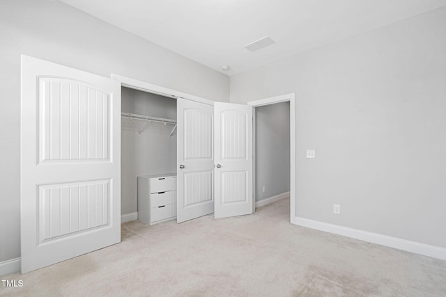 unfurnished bedroom featuring light colored carpet and a closet