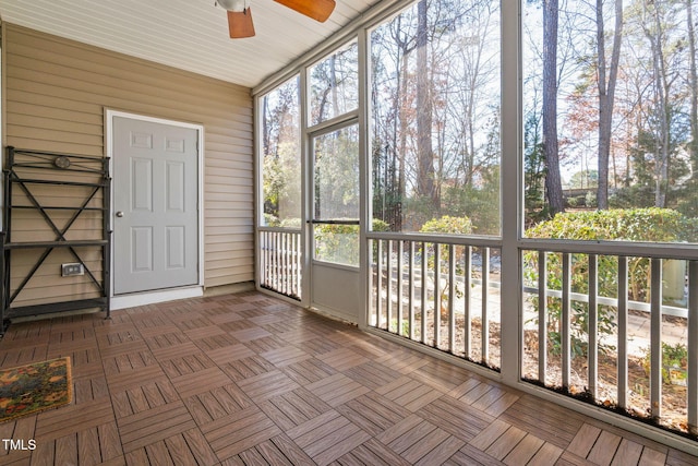 unfurnished sunroom featuring ceiling fan