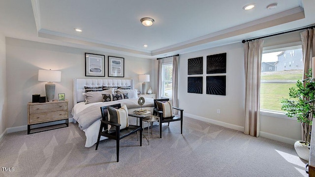 bedroom with light carpet, a tray ceiling, and crown molding