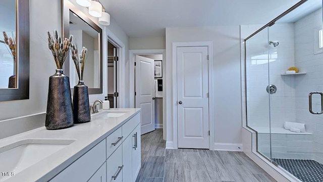 bathroom with hardwood / wood-style flooring, vanity, and an enclosed shower