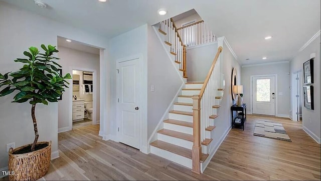 stairway with crown molding and hardwood / wood-style floors