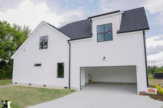 rear view of property featuring a yard and a garage