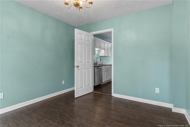 310 Interchange Dr, Fayetteville, NC 28311 - spare room with sink, dark hardwood / wood-style flooring, a textured ceiling, and a chandelier