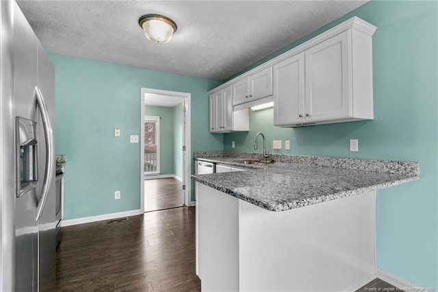310 Interchange Dr, Fayetteville, NC 28311 - kitchen with kitchen peninsula, dark hardwood / wood-style flooring, a textured ceiling, stainless steel appliances, and white cabinetry