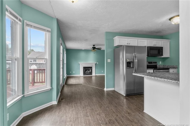 310 Interchange Dr, Fayetteville, NC 28311 - kitchen featuring white cabinets, a textured ceiling, dark hardwood / wood-style flooring, and stainless steel appliances