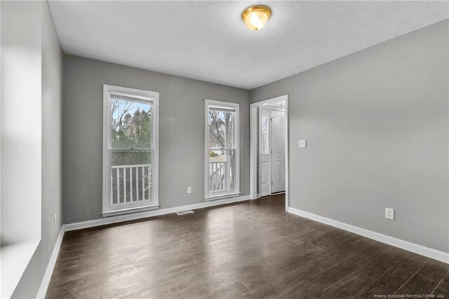 310 Interchange Dr, Fayetteville, NC 28311 - spare room with a textured ceiling and dark wood-type flooring