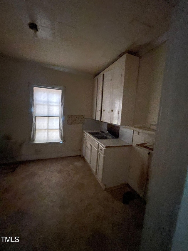 kitchen with white cabinets and light carpet