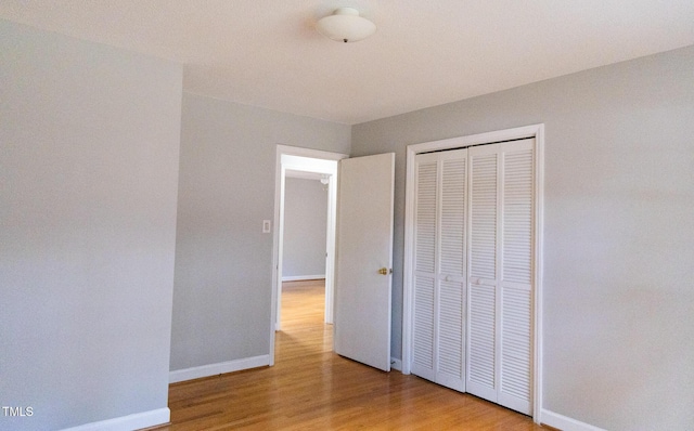 unfurnished bedroom featuring a closet and hardwood / wood-style flooring