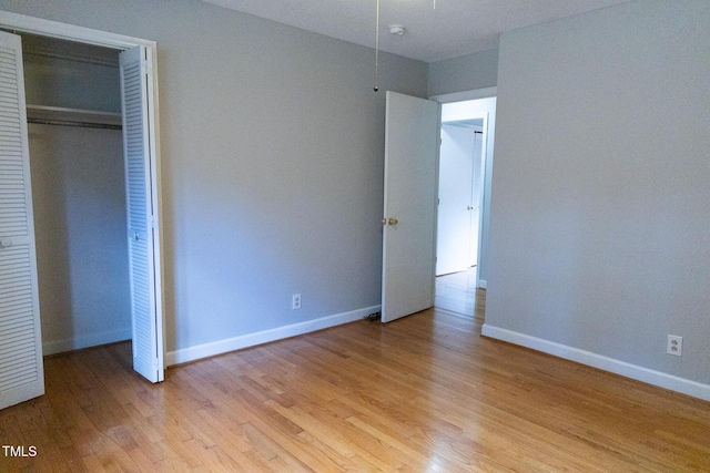 unfurnished bedroom featuring a closet and light wood-type flooring