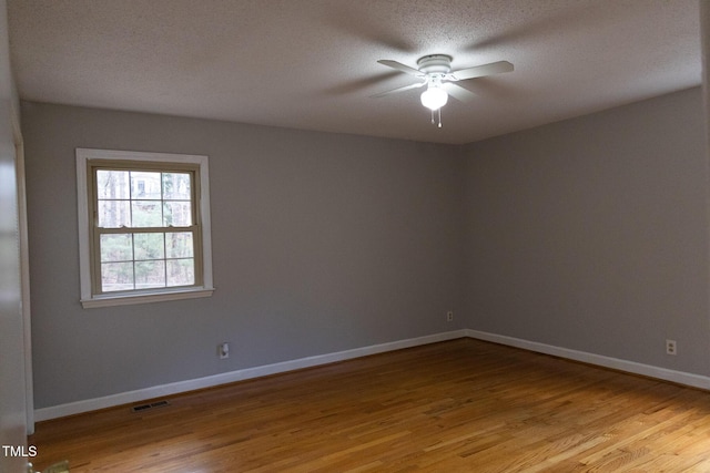 spare room with ceiling fan, light hardwood / wood-style flooring, and a textured ceiling