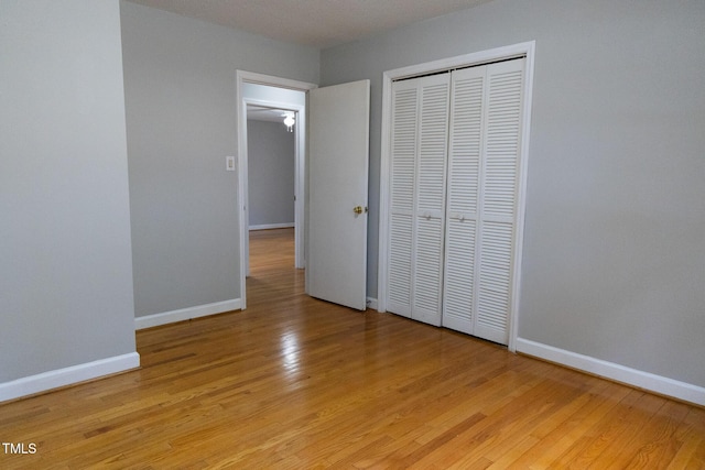 unfurnished bedroom featuring light hardwood / wood-style floors and a closet