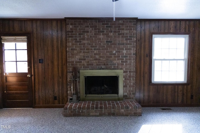 unfurnished living room featuring wood walls and a wealth of natural light