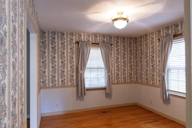 spare room featuring hardwood / wood-style floors and a textured ceiling