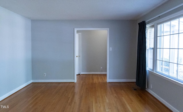 empty room featuring hardwood / wood-style flooring and a textured ceiling