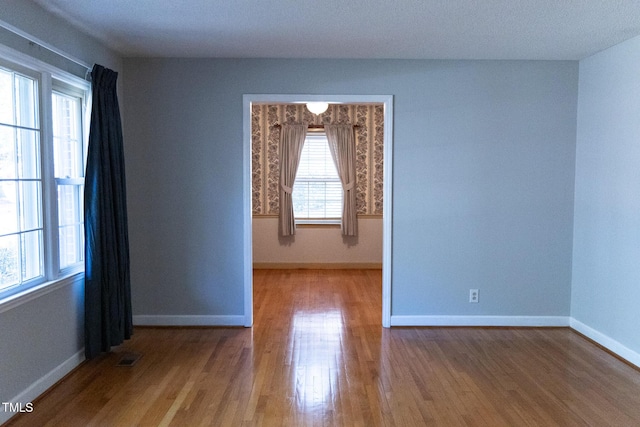 unfurnished room featuring hardwood / wood-style floors and a healthy amount of sunlight