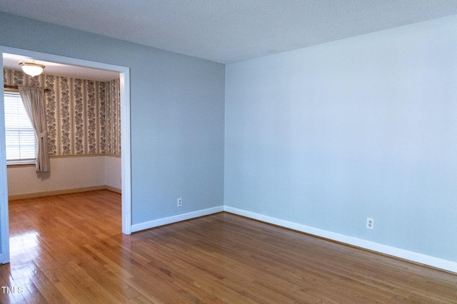 empty room featuring hardwood / wood-style flooring and a textured ceiling