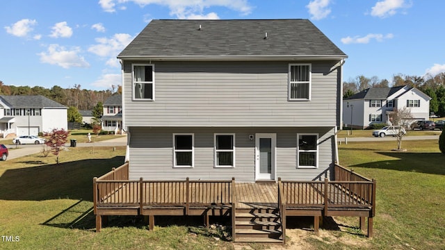 rear view of property featuring a lawn and a deck