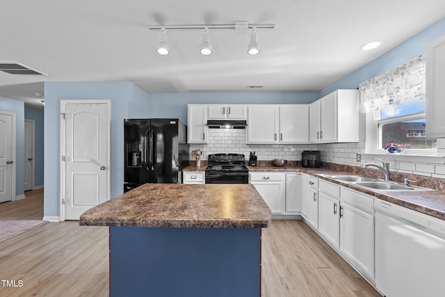 kitchen featuring light wood-type flooring, tasteful backsplash, black appliances, white cabinets, and a center island