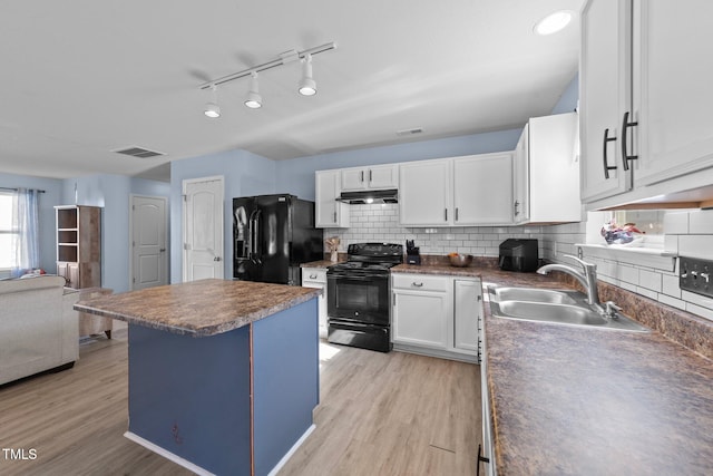 kitchen featuring white cabinetry, sink, decorative backsplash, black appliances, and light wood-type flooring