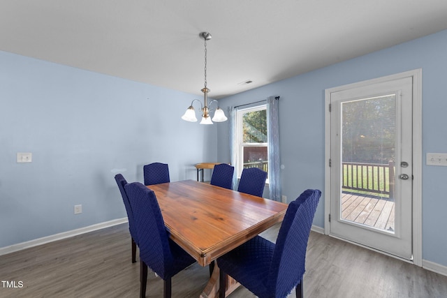 dining area featuring hardwood / wood-style floors and an inviting chandelier