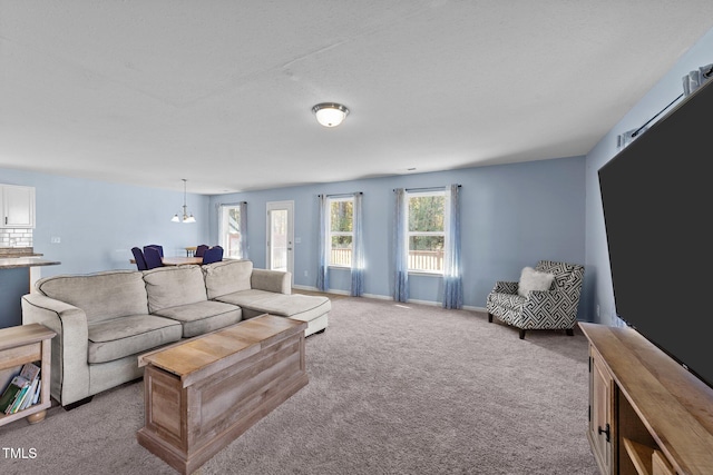 carpeted living room with a notable chandelier