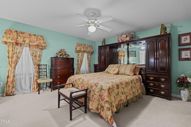 bedroom featuring light carpet, a textured ceiling, and ceiling fan