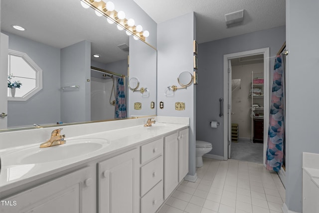 bathroom with a shower with curtain, vanity, a textured ceiling, tile patterned flooring, and toilet