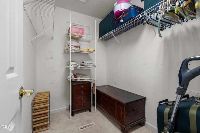 walk in closet featuring light colored carpet