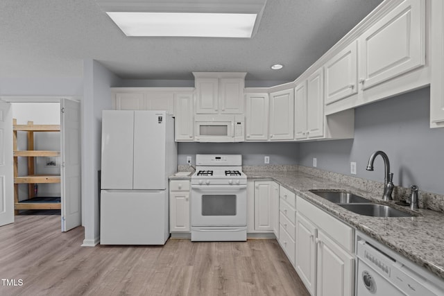 kitchen with white cabinets, white appliances, and sink