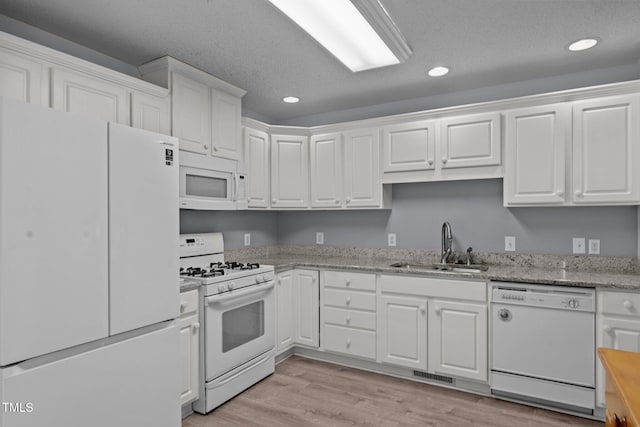 kitchen featuring white cabinets and white appliances