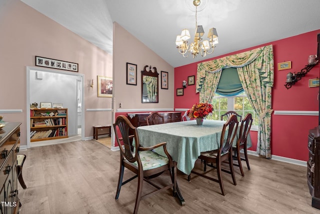 dining area featuring light hardwood / wood-style flooring, lofted ceiling, and an inviting chandelier