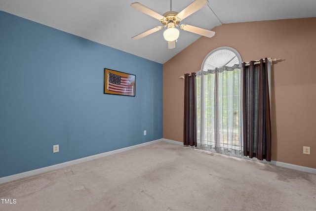 carpeted spare room featuring ceiling fan and vaulted ceiling