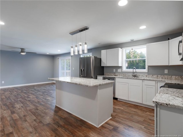 kitchen with white cabinets, dark hardwood / wood-style floors, decorative light fixtures, a kitchen island, and stainless steel appliances