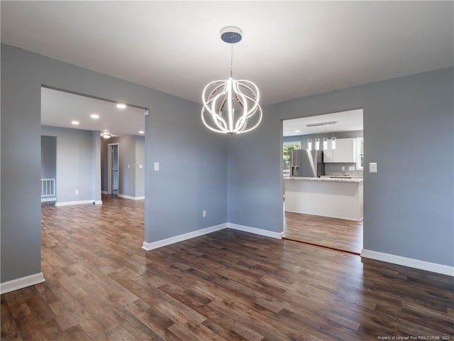 unfurnished dining area with an inviting chandelier and dark wood-type flooring