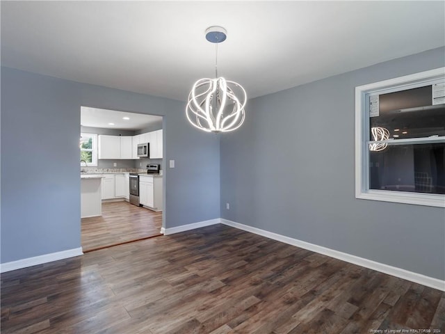 unfurnished dining area with dark hardwood / wood-style flooring and an inviting chandelier