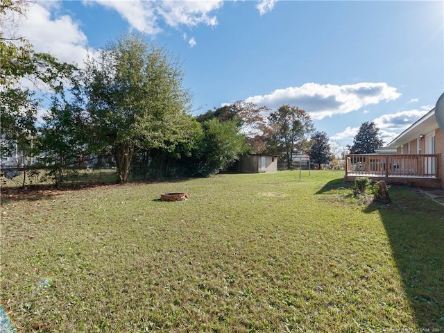 view of yard featuring an outdoor fire pit and a deck