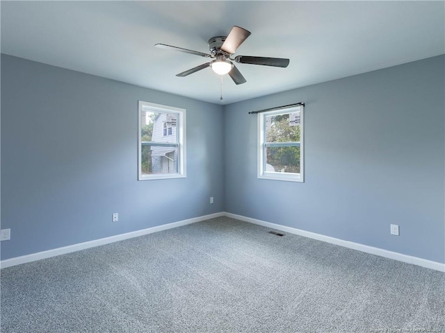 carpeted empty room featuring ceiling fan and a healthy amount of sunlight