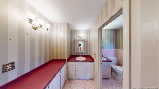 3327 Seven Mountain Dr, Fayetteville, NC 28306 - bathroom featuring vanity, toilet, and wallpapered walls