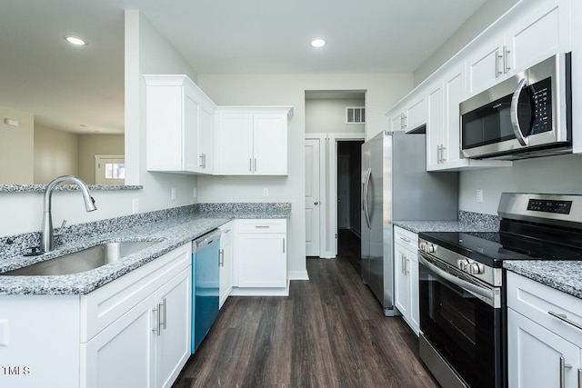 kitchen featuring a sink, visible vents, white cabinets, appliances with stainless steel finishes, and light stone countertops