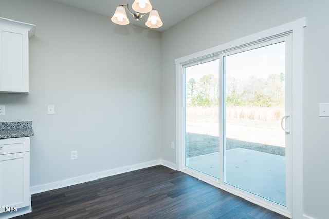 unfurnished dining area with baseboards, a chandelier, and dark wood-type flooring