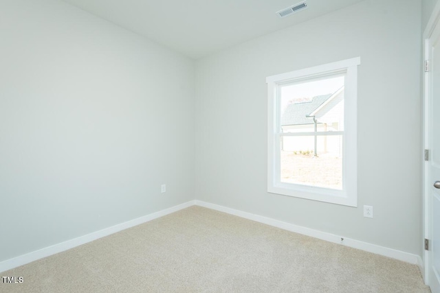 carpeted spare room featuring baseboards and visible vents