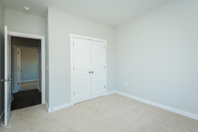 unfurnished bedroom with carpet, baseboards, and a closet