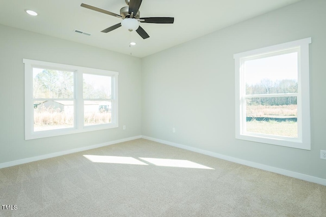 unfurnished room with ceiling fan, recessed lighting, light colored carpet, visible vents, and baseboards