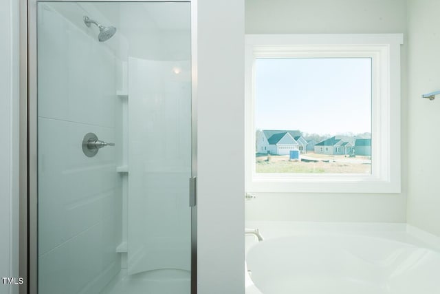 full bath featuring a garden tub and a shower stall