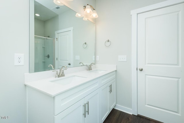 bathroom featuring double vanity, a stall shower, a sink, and visible vents