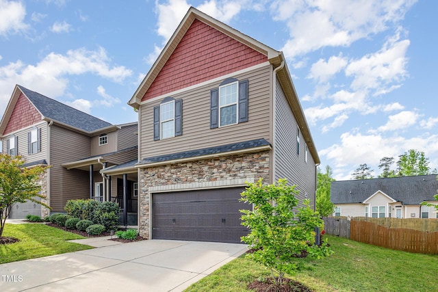 craftsman house featuring an attached garage, driveway, a front yard, and fence