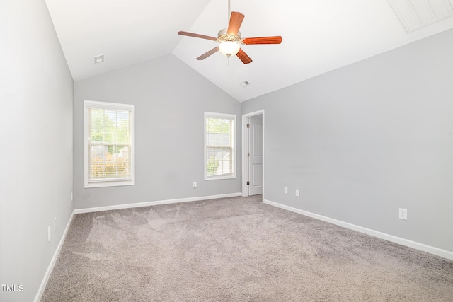 carpeted empty room featuring lofted ceiling, visible vents, a ceiling fan, and baseboards