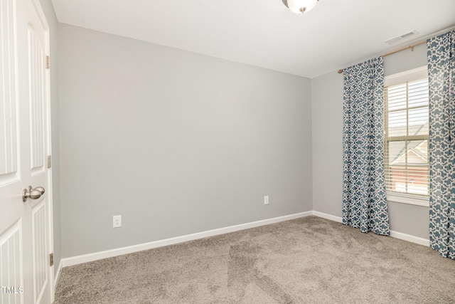 empty room featuring baseboards, carpet flooring, and visible vents